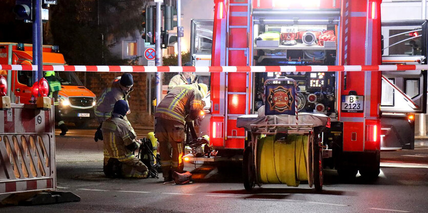 Die Feuerwehr steht mit Einsatzwagen vor einem Haus in Berlin. Der Bereich ist abgesperrt.