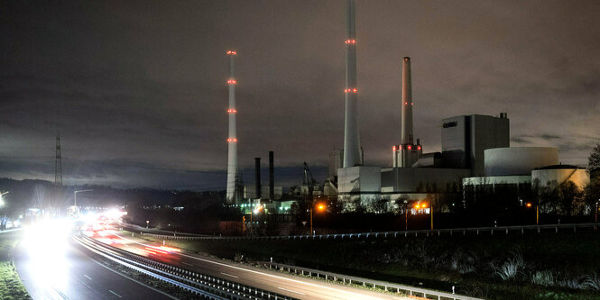 Autos fahren in der Dunkelheit an dem Kohlekraftwerk Altbach/Deizisau vorbei