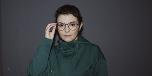 Porträt von Natalya Nepomnyashcha mit Brille und grünem Hoodie