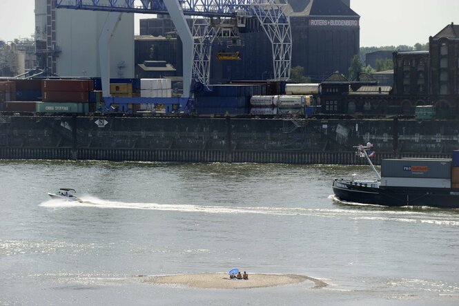 Menschen sitzen auf einer Sandbank im Rhein