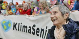 Seniorin vor Banner mit der Aufschrift "Klimaseniorinnen"