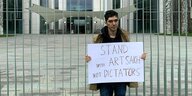 Arshak Makichchyan steht mit einem Schild vor dem Bundeskanzleramt in Berlin: "Stand with Artsakh not Dictators"
