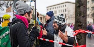 Zwei Männer sprechen miteinander auf einer Demo