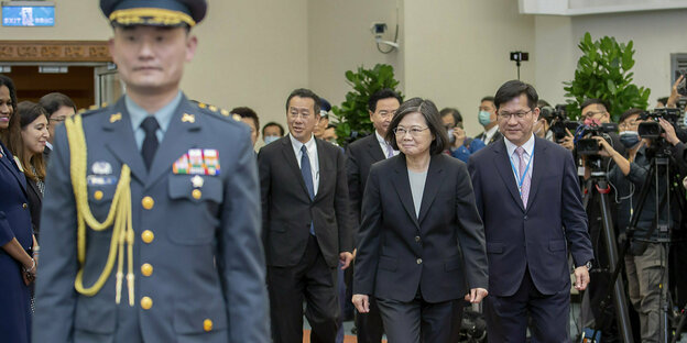 Taiwans Präsidentin Tsai Ing-wen mit Entourage und Journalisten, im Vordergrund ein dekorierter Soldat in strammer Haltung
