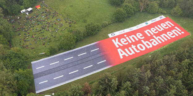 Riesiges Protesbanner auf einer Lichtung aus der Luft fotografiert: "Keine neue Autobahn"