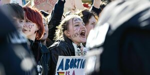 Eine junge Frau demonstriert mit der Aufschrift "my choice" im Gesicht gegen den Paragraphen 218