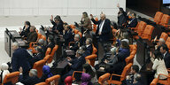 Abgeordnete im Plenarsaal heben die Hand zur Abstimmung