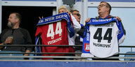 Zwei HSV-Fans halten ein Trikot von Mario Vušković hoch