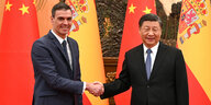 Pedro Sanches und Xi Jinping schütteln sich die Hände vor ihren Landesfahnen
