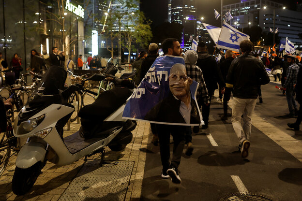 Ein Demonstrant ist in ein Plakat gehüllt, das Netanjahu zeigt Ein Demonstrant ist in ein Plakat gehüllt, das Netanjahu zeigt