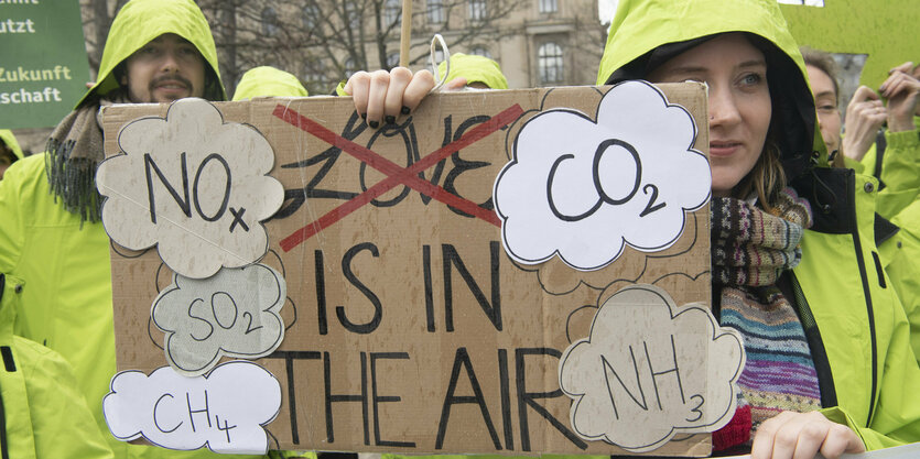 Zwei Menschen tragen bei Regen ein Plakat gegen den Klimawandel