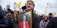 Mann in Menschenmenge mit Bild von Johannes Paul II.