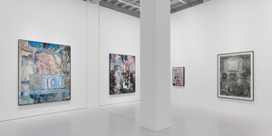 Blick in die neue Ausstellung von Adrian Ghenie in der Galeria Plan B. Vier Gemälde in unterschiedlichen Größen zieren zwei Wände, in der Mitte ist eine raumtragende Säule zu sehen. Auf dem Bild ganz links, das von blauen Linien überzogen ist, beugt sich einen Person von einem Balkon.