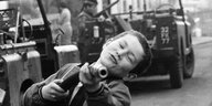 Schwarz-weiß-Aufnahme eines Kindes, das mit einer Waffe spielt