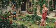Zwei Frauen stehen sich in einem Garten gegenüber