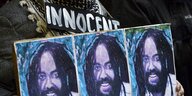 Drei Plakate mit dem Konterfei von Mumia Abu Jamal