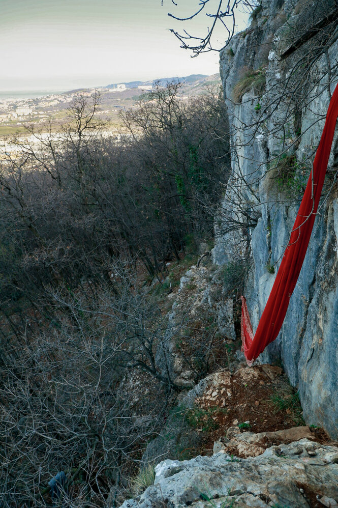 An einem steilen Felsen ist eine Rote Schnur angebracht