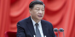 Chinas Machthaber Xi Jinping bei einer Rede am Montag in Peking vor rotem Hintergrund.