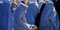 In hellblaue Burkas verhüllte Afghaninnen warten im August 2022 in Kabul auf die Verteilung von Lebensmittelrationen.