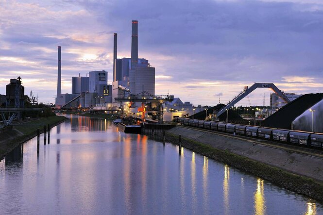 Im Vordergrund ist der Rhein in Mannheim zu sehen, im Hintergrund ein großes Kraftwerk.