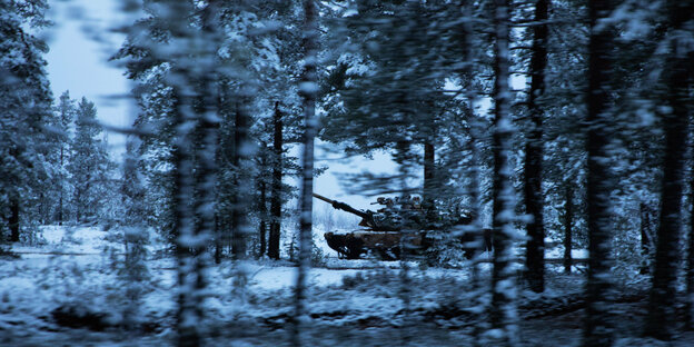 Ein Panzer fährt durch einen schneebedeckten Wald