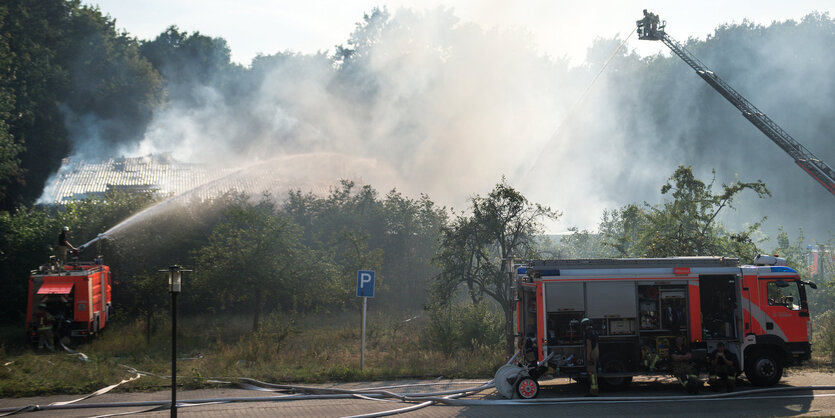 Ein Feuerwehrauto, ein Löschzug, viel Wasser und Qualm.