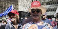 Ein Mann und eine Frau mit Hut worauf steht: Keep America Great