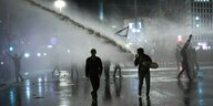 Menschen demonstrieren, der Strahl eines Wasserwerfers ist zu sehen, jemand schwenkt eine Israelfahne
