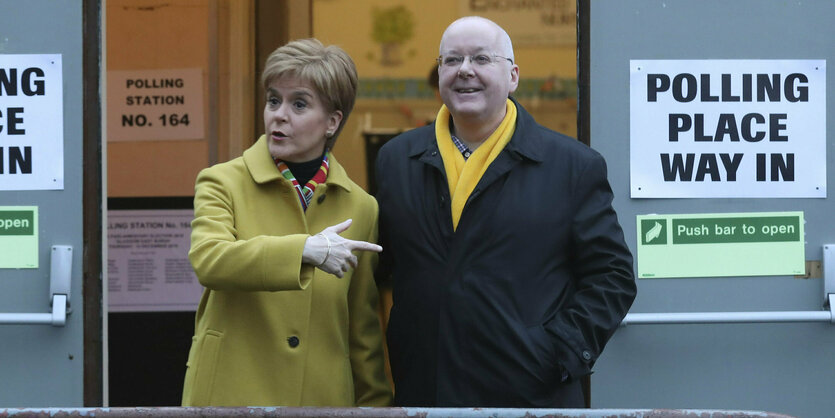 Nicola Sturgeon zeigt vor einem Wahllokal in Glasgow im Dezember 2019 auf ihren Ehemann Peter Murrell