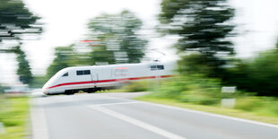 Ein ICE fährt über einen Bahnübergang.