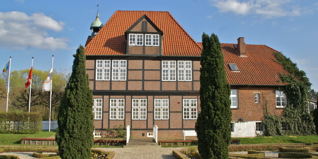 Ein rot verklinkertes Fachwerkhaus mit Garten