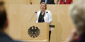 Nancy Faeser (SPD), Bundesinnenministerin, steht an einem Redepult, auf dem der Bundesadler prangt