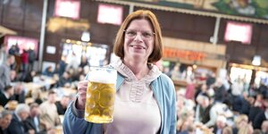 Kristina Vogt (Die Linke,), Wirtschaftssenatorin von Bremen, hält zur Eröffnung der Osterwiese 2023 einen Bierkrug in die Kamera