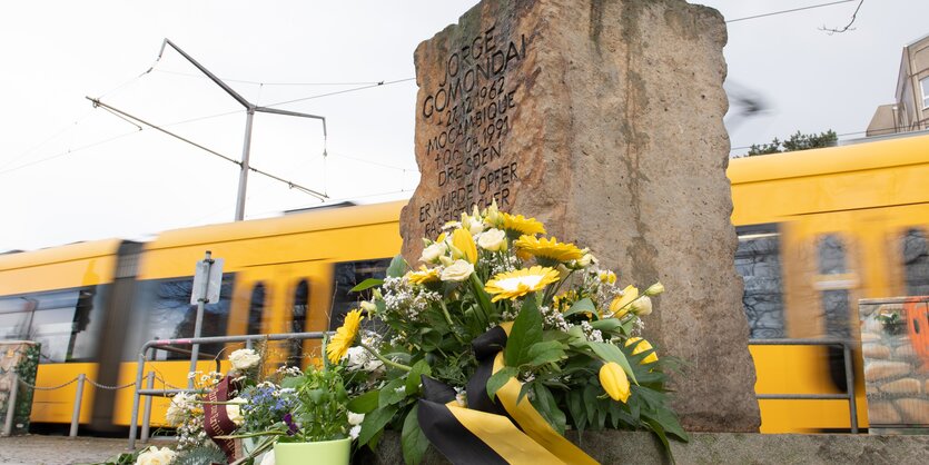 Gedenkstein mit Blumen und Kerzen