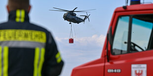 Ein Hubschrauber transportiert Wasser