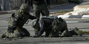 Behelmte israelische Polizisten in Kampfanzügen entfernen auf einer Straße in Schlomi Reste eine abgefangenen Rakete, die aus dem Libanon abgefeuert worden war