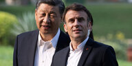 Xi Jinping und Emmanuel Macron spazieren in einem Garten