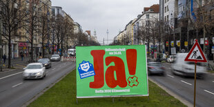 Ein Plakat mit der Aufschrift „Ja! - Berlin 2030 Klimaneutral“ steht auf der Frankfurter Allee.