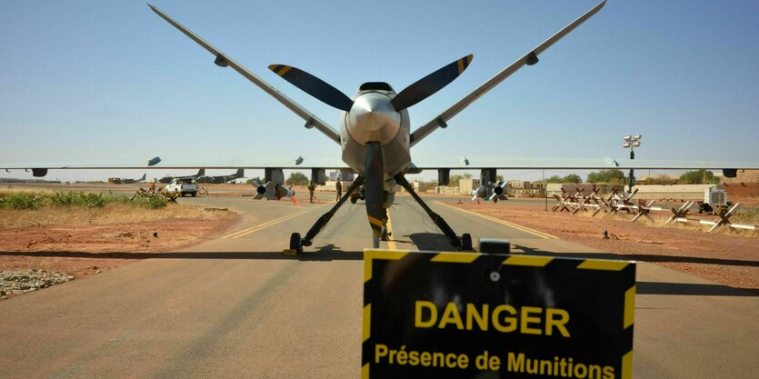 Ein Flugzeug steht auf einer Landebahn, davor steht ein Schild mit der Aufschrift Danger