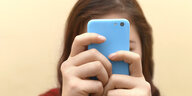 Teenager mit Smartphone vorm Gesicht
