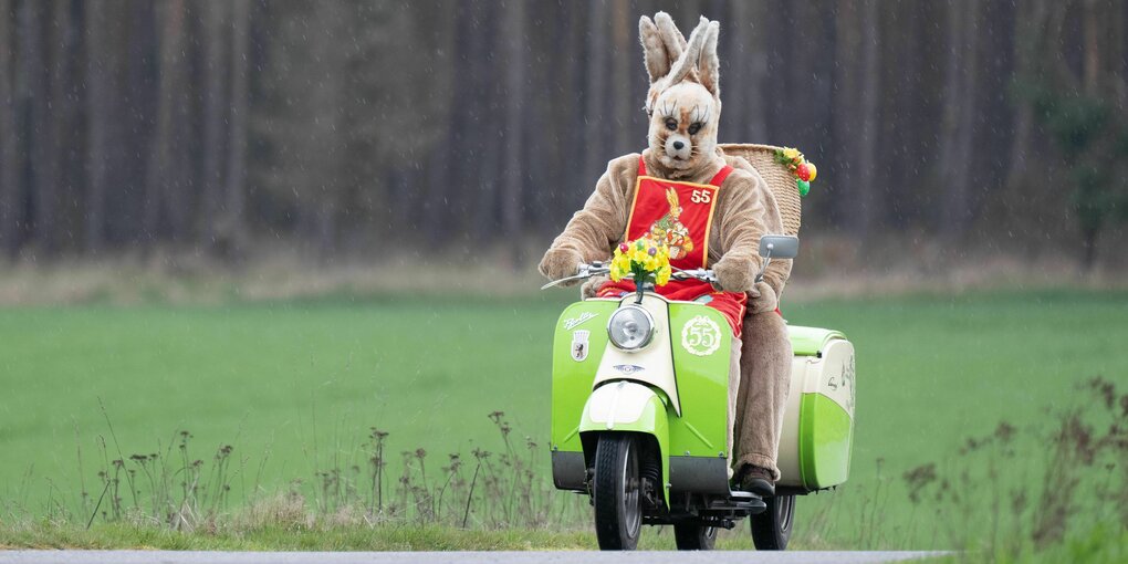 Dieter Melzer fährt mit seiner Tochter Carina Melzer-Wetzig in einem Osterhasenkostüm auf einem Berliner Roller durch Brandenburg.