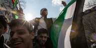Menschen bei einer Demonstration mit Palästina-Flagge