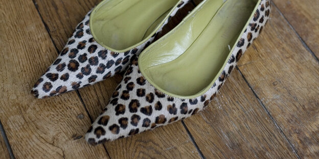 Spitze Schuhe im Leopardenmuster stehen auf einem Holzparkett