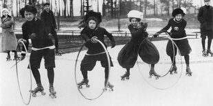 Frauen mit Hüten bei einem Rollschuh-Straßenwettlauf mit Reifen, historische Aufnahme