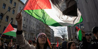 Person auf einer Demonstration mit Palestina-Flagge
