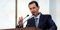 Syriens Präsident Baschar Al-Assad spricht in ein Mikrofon