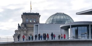 Menschen schauen von der Bundestagsbrücke zwischen Paul-Löbe-Haus und dem Marie-Eleisabeth-Lüders-Haus auf den Reichstag
