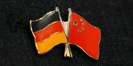 Anstecker in Form einer Chinafahne und einer Deutschlandfahne