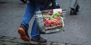 Person mit gefüllter Einkaufstasche auf der Strasse