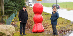 Michael Dörner, Professor an der Kunsthochschule Ottersberg, und Kira Keune, Studentin, stehen an der Bundesstraße 209 neben einem Kunstobjekt.
